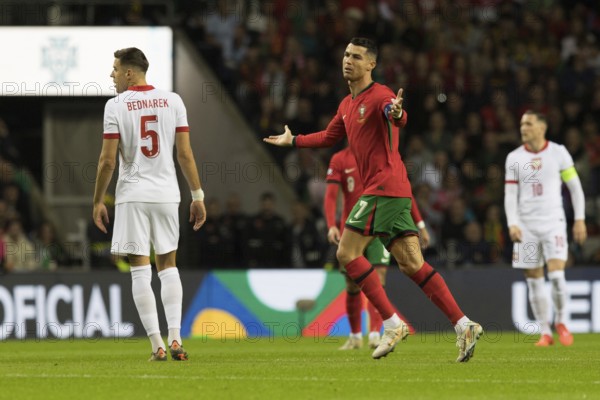 Football match, captain Cristiano RONALDO CR7 Portugal centre with both arms pointing upwards not saying so running with his eyes to the left, Jan BEDNAREK Poland left looking from behind and looking to the right, in the background captain Piotr ZIELINSKI Poland right, Estadio do Dragao, Porto, Portugal, Europe