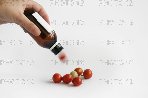 Tomatoes from the medication bottle solated on white