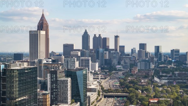 Aerial views of Atlanta showcase a vibrant cityscape with sleek skyscrapers, lush green spaces, and iconic landmarks like Mercedes-Benz Stadium. Highways, railroads, and hills weave through this bustling metropolis, Atlanta, United States of America