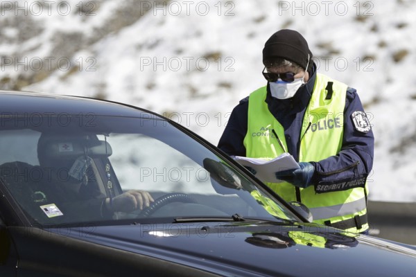 Sofia, Bulgaria - 3 April, 2020: A police officer checks a car drriver at one of the exits of Sofia, following restrictions on non-essential travel between cities and towns due to coronavirus disease