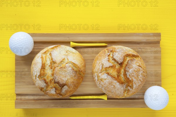 Golf breakfast - Two wheat bread and golf balls on wooden desk