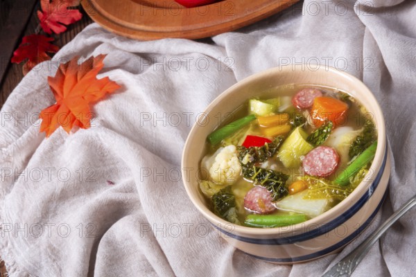 Delicious autumn vegetable soup with sausage and bacon