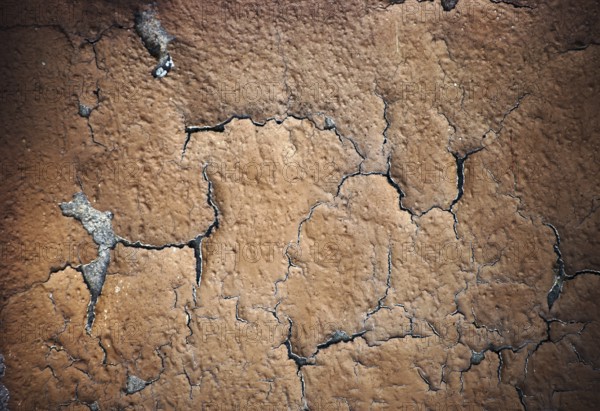 The close-up of peeling layers of plaster and paint on a concrete wall