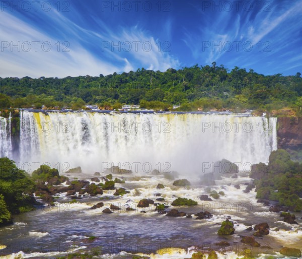 Incredible exotic waterfalls of Iguazu on the border of Brazil, Argentina and Paraguay. Concept of active and extreme tourism. Huge stones and boulders among the raging water