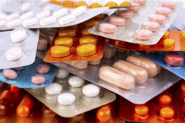 Different colorful capsules and pills in plastic packs - blisters stacked. Global pharmaceutical industry for billions dollars per year. Pharmaceutical drugs for use as medications. Studio shot