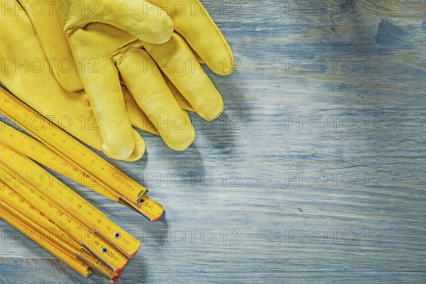 Wooden meter pair of leather safety gloves on wood board construction concept