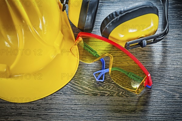 Building helmet goggles earmuffs on wooden board