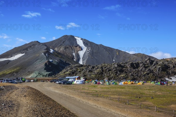 Rhyolite mountains surround the flat valley of National Park Landmannalaugar. Big tourist camp is located in the valley of the park