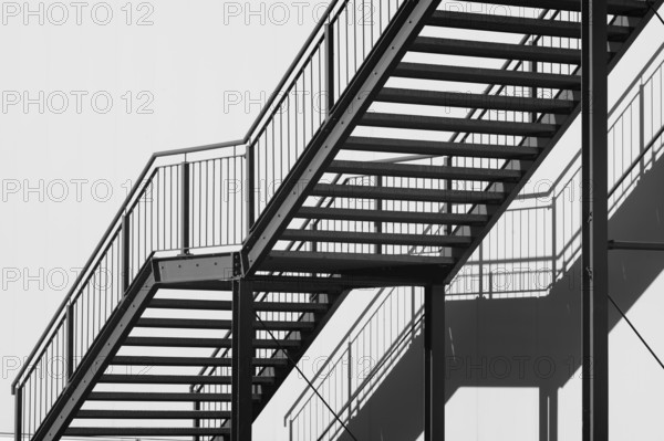 Greyscale shot outdoor stairway to the building in the sun