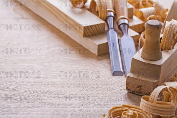 Organized copspace woodworkers plane carpentry chisels shavings on wooden board construction concept