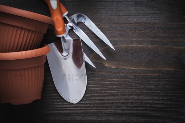 Clay gardening pots trowel fork and hand spade on vintage wood board agriculture concept