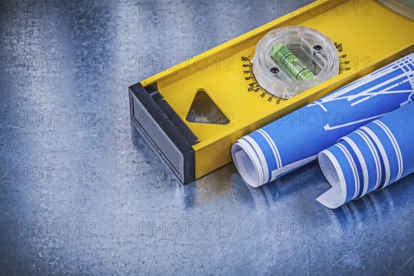 Blue engineering drawings construction level on metallic background maintenance concept