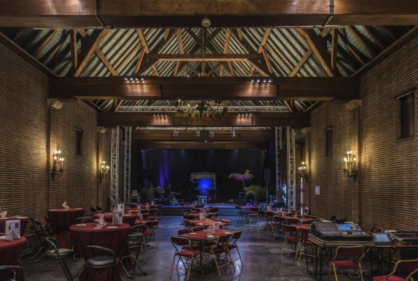 Belgium, 02 16 2019: Interior of the main event room of the old Karreveld farm with decorated tables for dinner and traditional wooden timber frame construction, Europe