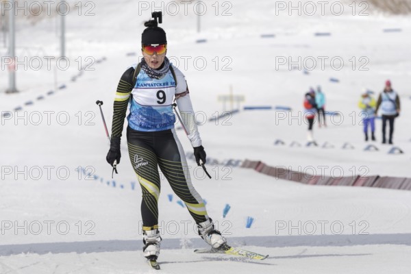 Korean sportswoman biathlete skiing at finish after rifle shooting. Lee Hyunju South Korea during Regional youth biathlon competitions East Cup. Kamchatka Peninsula, Russian Far East, Apr 13, 2019