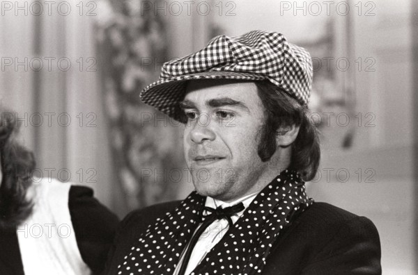 Elton John. English singer, songwriter born march 25 1947. Pictured wearing a chequered cap and a matching chequered scarf during a visit to Sweden 1978. Kristoffersson