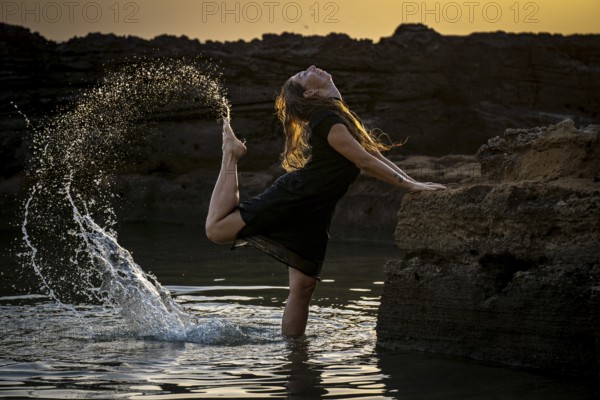 Middle-aged woman dancing and throwing water in the air, Maioris beach, llucmajor, Majorca, Balearic Islands, Spain, Europe