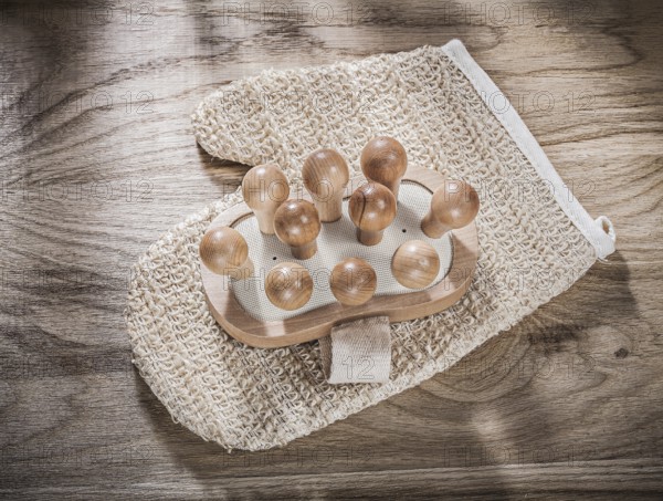 Massager body scrubber on wooden board healthcare concept