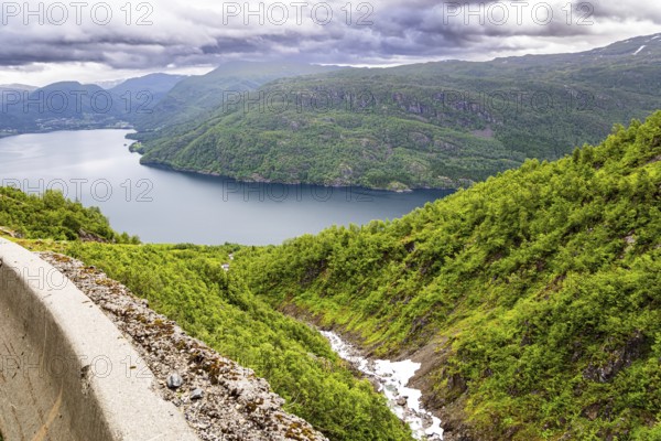 Magnificent panorama of the fjord. Norway. Traveling by camper on road 520. The road is fenced with a concrete fence