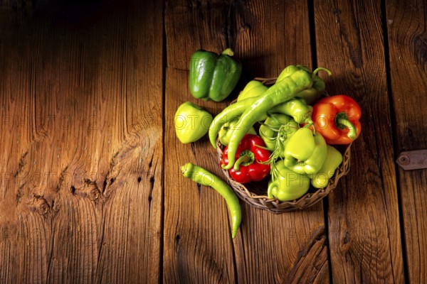 Various harvested peppers and hot peppers in a basket