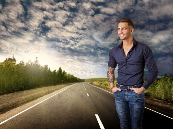 Handsome young man in blue shirt and jeans posing isolated on white background in studio, smiling