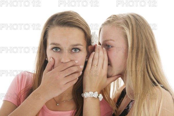 Teen girls are whispering gossip to each other