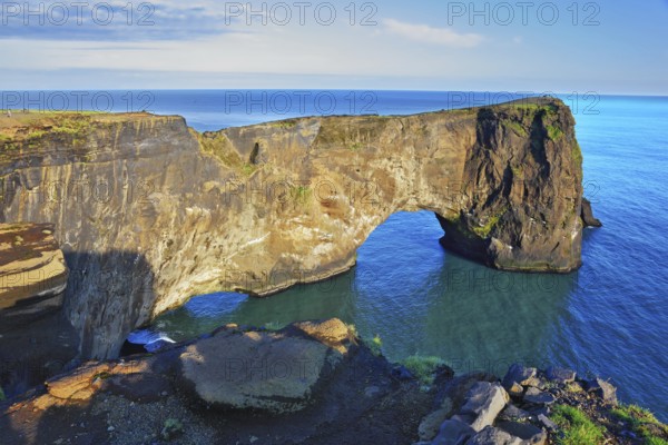 The cape Dirkholaey in the south of Iceland. The enormous rock elephant it is lit with a summer. The sunset in July