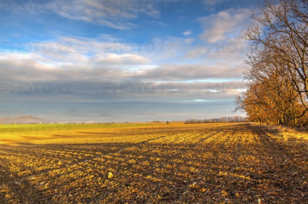Autumn morning landscape over the city of Louny. Autumn plowed field at amazing sunrise. Czech Republic