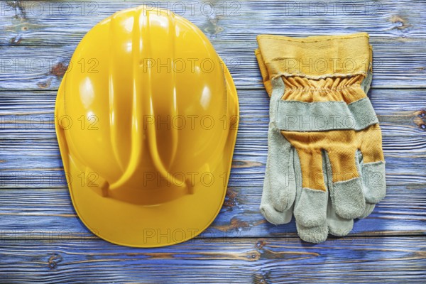 Safety gloves building helmet on vintage wooden board