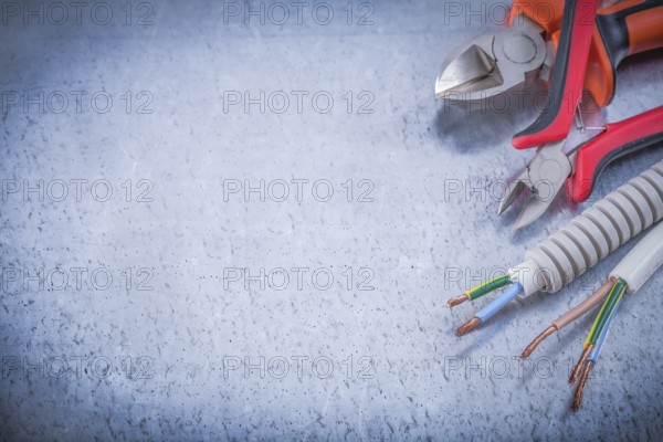 Sharp cutting pliers corrugated pipe wire protection on metallic background