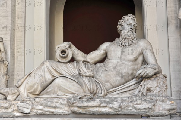 Vatican Museums, Vatican, Rome, Italy, Antique marble sculpture of a bearded man in a relaxed reclining position in front of a niche, Vatican, Rome, Lazio, Italy, Europe