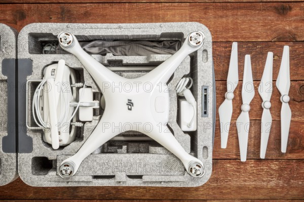 FORT COLLINS, CO, USA - DECEMBER 11, 2016: DJI Phantom 4 pro quadcopter drone in a custom case on a rustic wooden table with a set of propelelrs
