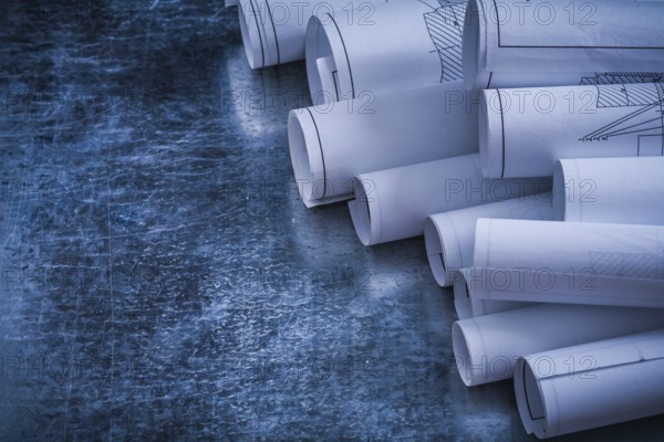 Metallic vintage background with heap of white blueprint rolls building and architecture concept