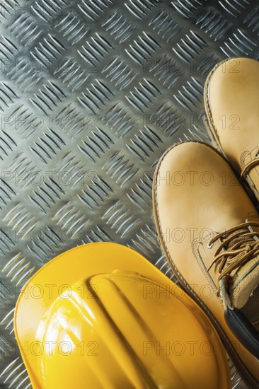Waterproof boots building helmet on corrugated metal sheet