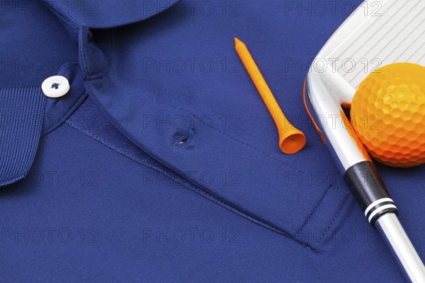 Detail of blue polo shirt and golf equipments