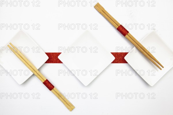 Ceramic bowls and bamboo chopsticks for sushi food with red and white decoration