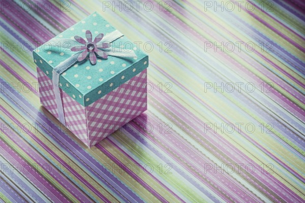 Wrapped gift box on stripy fabric background celebrations concept