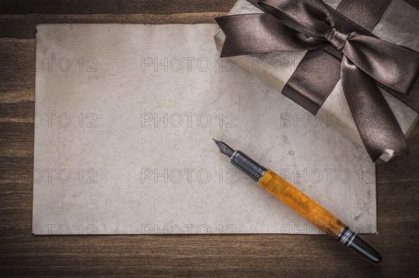 Present box brown bow paper fountain pen on wood board