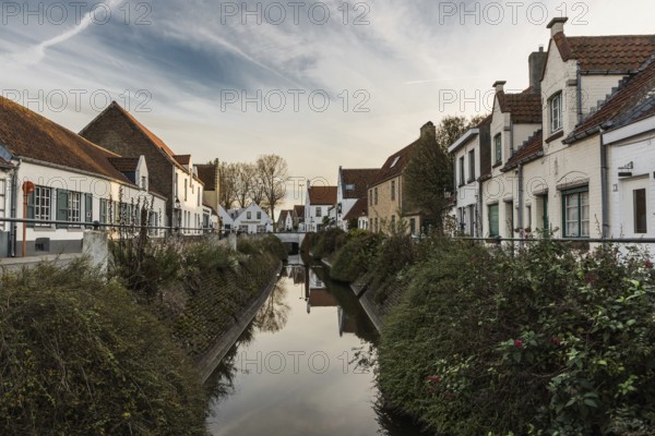 Lissewege, Flanders, Belgium, 10 30 2018: View over the old paved streets, houses and a creek during sunset, Europe