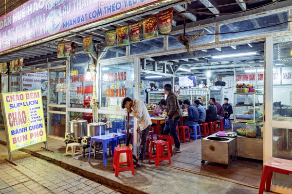 A street restaurant at night with diners at tables and vibrant neon lights, restaurant in the streets of Sa Pa in Vietnam