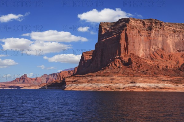 Lake Powell is surrounded by magnificent red hills. Scenic huge artificial water basin of the Colorado River, USA. Walk on the boat at sunset