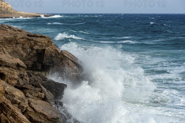 Waves crashing on rocky coast. Windy weather, Powerful sea waves braking on rocks