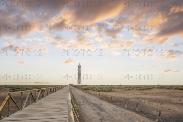 Dusk, landscape shot with lighthouse in nature reserve. View of the sea at sunset. Lighthouse during a light calima, sandstorm in Morro Jable, Fuerteventura, Canary Islands, Spain, Europe