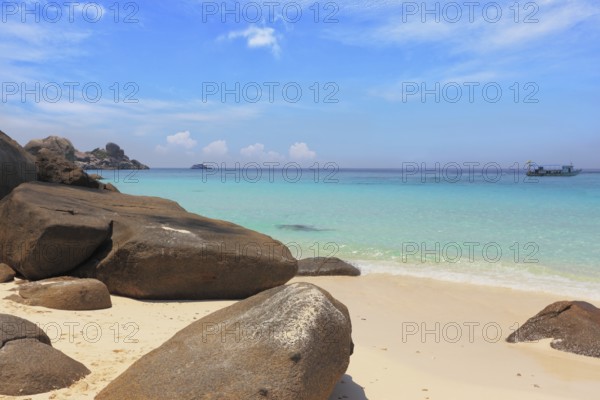 Similan Islands, Andaman Sea, Thailand. Finest white sand beach adjacent to the great brown cliffs and azure water. Unusual beach