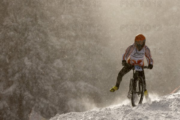 Sofia, Bulgaria - 22 January, 2022: Cyclist rides a bike downhill during an extreme snow riding mountain bicycle competition in Vitosha mountain