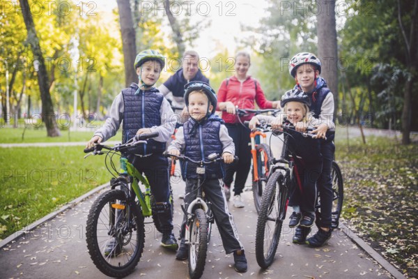 Theme family sports holiday in park in nature. big friendly Caucasian family of six people mountain bike riding in forest. Children brothers and sister stand on the background of parents in a row