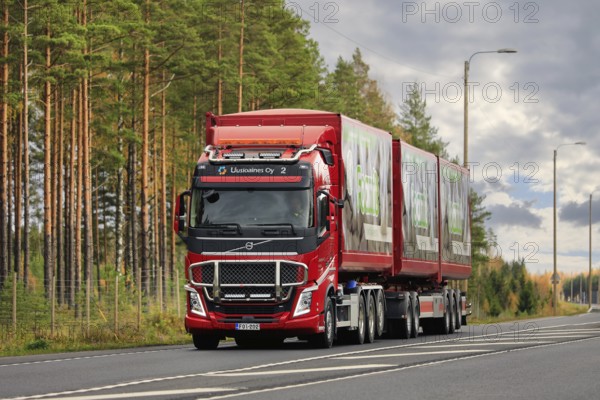Red Volvo FH of Uusioaines Oy hauling trailer load of Foamit foam glass aggregate along highway 2. Lohja, Finland. October 16, 2020