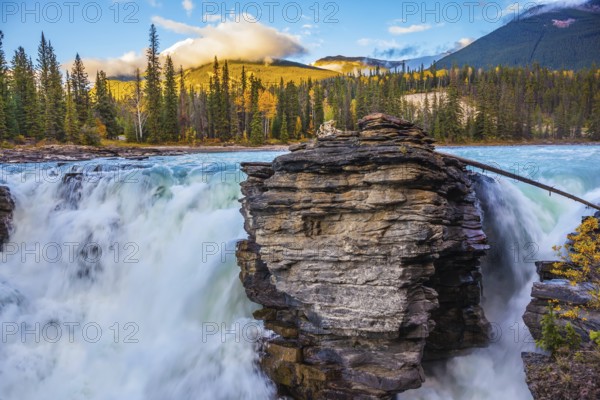 Powerful and scenic Athabasca Falls. Sunset illuminates the surrounding mountains. Canada, Jasper National Park