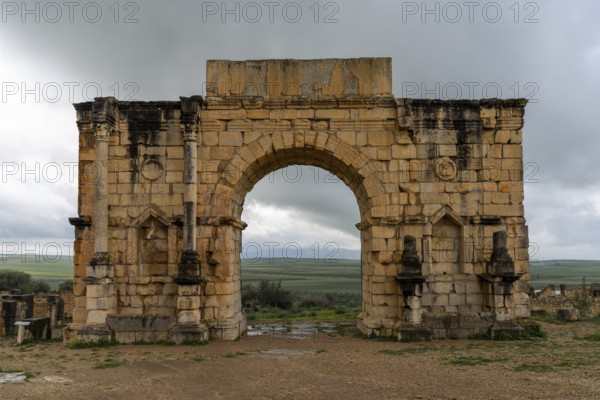 Volubilis, Morocco, 3 March, 2024: view of the ruins of the Triumphal Arch and city gate in the ancient Roman Berber city of Volubilis in Morocco, Africa
