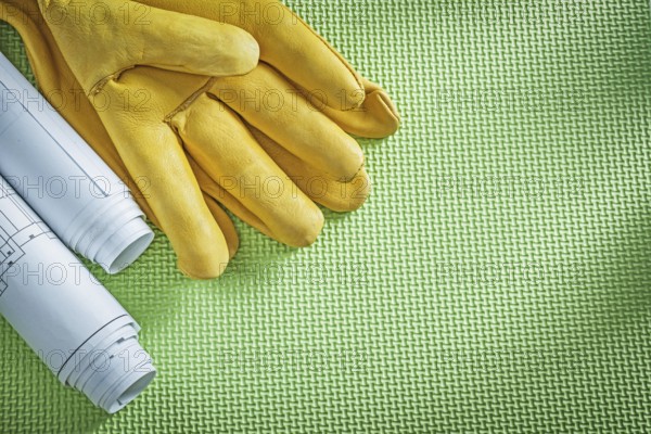 Protective leather gloves engineering drawings on green background construction concept
