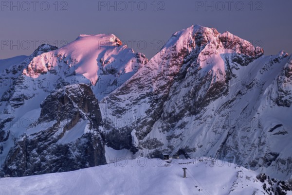 View from the top of Marmolada on the surrounding Dolomite hills after sunrise in winter